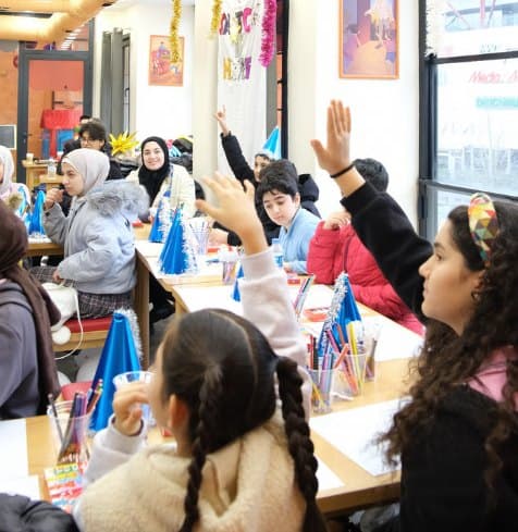 Atölyede söz almak için parmak kaldıran çocuklar